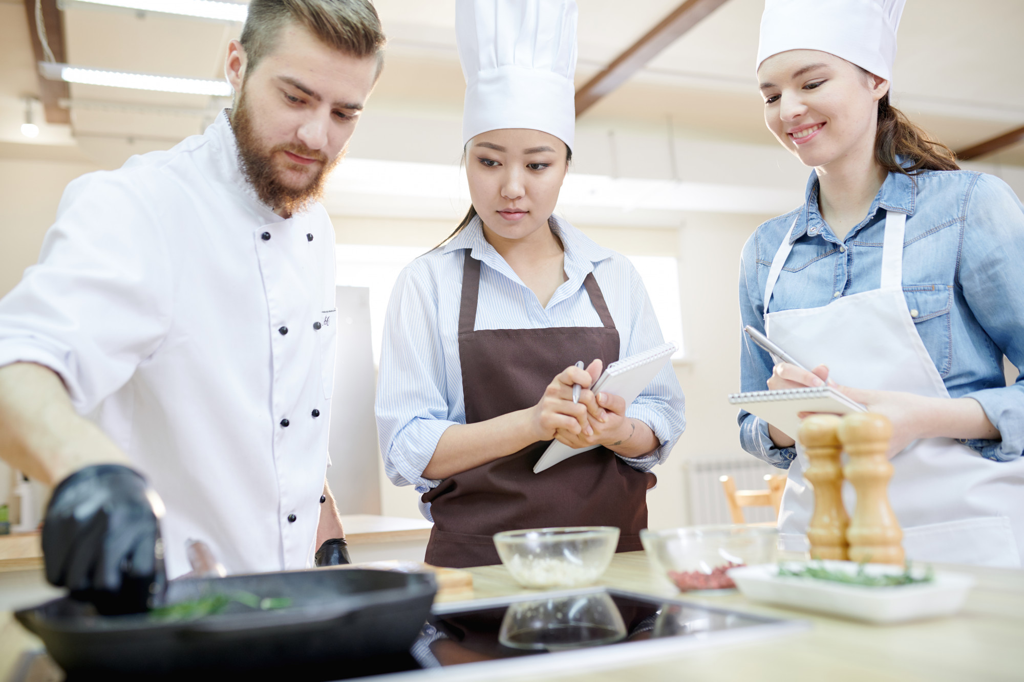 Instructor guiding students in a kitchen workshop